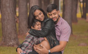 pregnant woman hugs son and husband